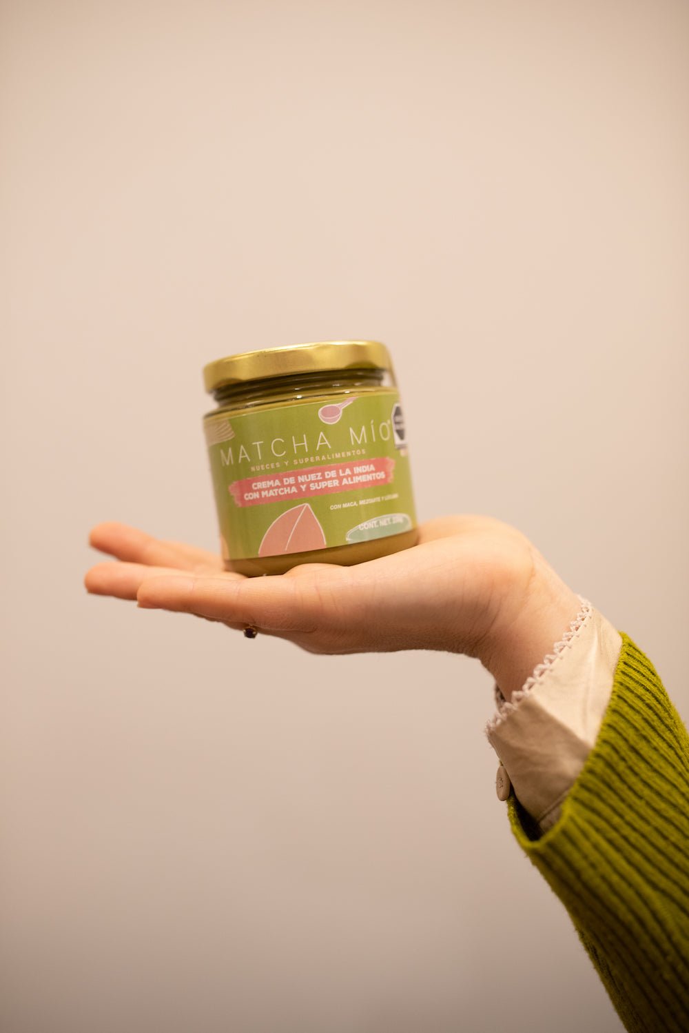 Crema de Nuez de la India con Matcha - vidta frontal en display sobre mano disfruta del untable cremoso irresistible y saludablecacaomio.com
